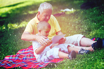 Image showing grandfather and child in park using tablet