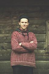 Image showing young hipster in front of wooden house