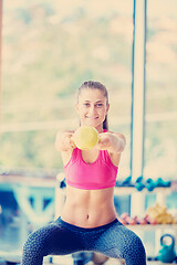 Image showing weights lifting  and working on her biceps in a gym