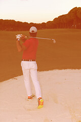 Image showing golfer hitting a sand bunker shot on sunset