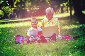 Image showing grandfather and child in park using tablet