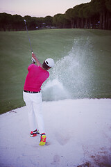 Image showing golfer hitting a sand bunker shot on sunset