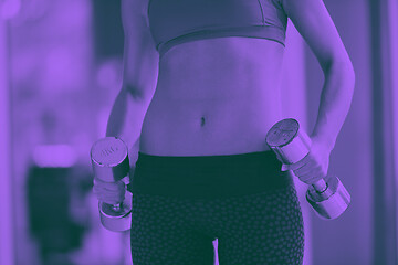 Image showing lifting some weights and working on her biceps in a gym