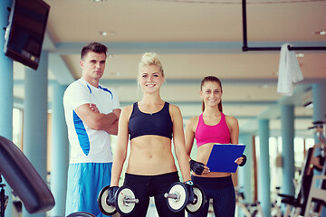 Image showing young woman in fitness gym lifting  weights