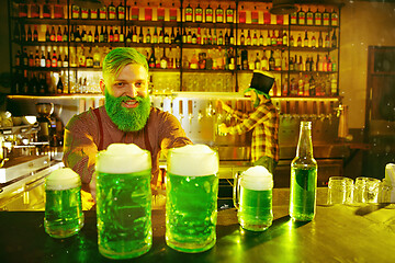 Image showing Happy man with glass of beer looking aside in pub