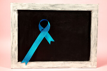 Image showing Colon cancer awareness poster. Blue ribbon made of dots on white background. Medical concept.