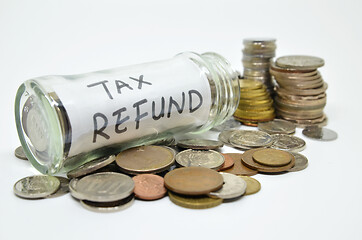 Image showing Tax refund lable in a glass jar with coins spilling out