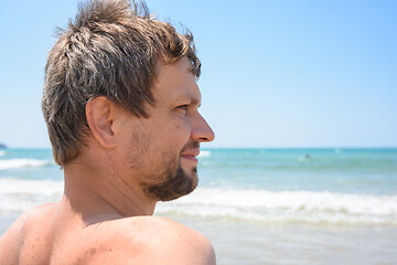 Image showing Portrait of an overgrown man of forty years against the background of the sea