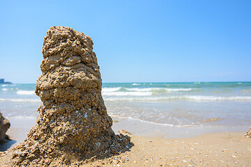 Image showing A pile of wet sand on the seashore, on the right there is an empty place for inscription