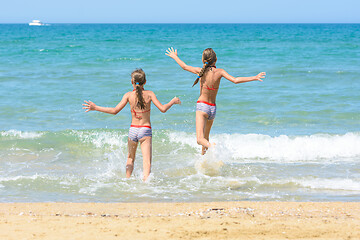 Image showing Cheerful children run to swim in the sea