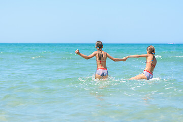 Image showing Two girls swim in the sea on a hot day
