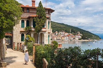 Image showing Female tourist walking along Adriatic sea coast relaxing on vacation in Moscenicka Draga, Istria, Croatia.