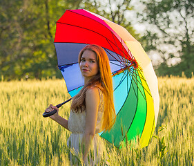 Image showing Cute girl with a multicolored umbrella