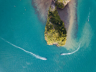 Image showing two boats go around a rocky island