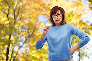 Image showing displeased senior woman in glasses warning