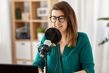 Image showing woman with microphone recording podcast at studio