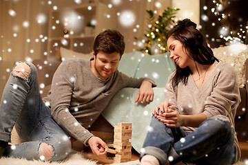 Image showing happy couple playing block-stacking game at home