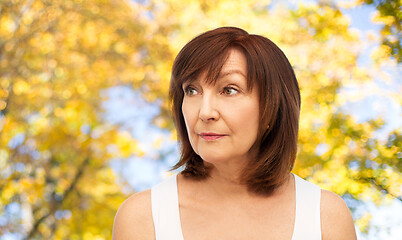 Image showing portrait of senior woman over autumn trees