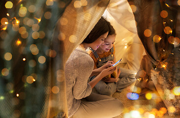 Image showing happy family with smartphone in kids tent at home