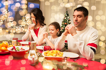 Image showing family praying before meal at christmas dinner