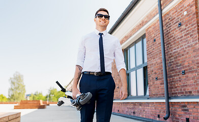 Image showing businessman with folding scooter on rooftop