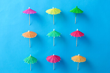 Image showing cocktail umbrellas on blue background