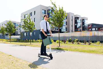 Image showing businessman with shopping bag riding scooter