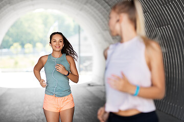 Image showing women or female friends with earphones running