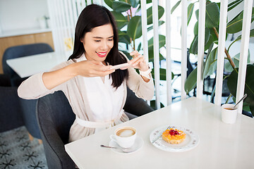 Image showing woman photographing coffee by smartphone at cafe