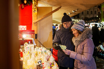 Image showing happy senior couple hugging at christmas market