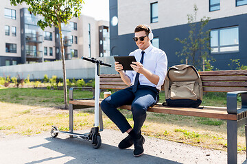 Image showing businessman with tablet pc, headphones and scooter