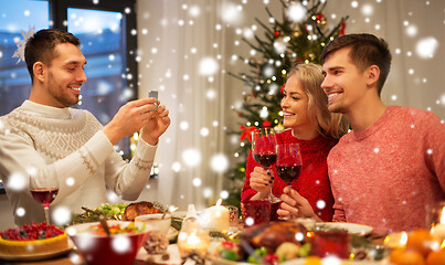 Image showing happy friends photographing at christmas dinner