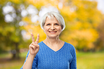 Image showing senior woman showing peace in autumn park