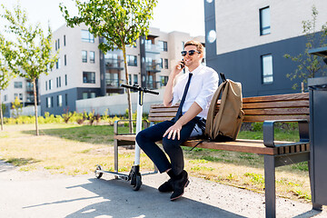 Image showing businessman with scooter calling on smartphone