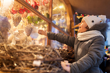 Image showing girl choosing christmas decorations at market