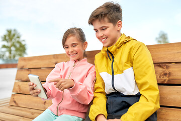 Image showing children with smartphones sitting on street bench