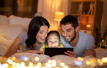 Image showing family with tablet pc in bed at night at home