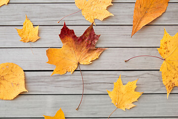 Image showing dry fallen autumn leaves on gray wooden boards