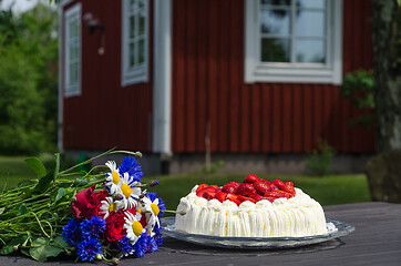 Image showing Flowers and strawberry cake on a table