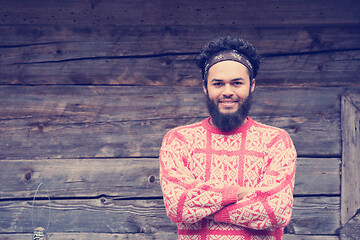 Image showing portrait of young hipster in front of wooden house