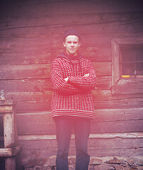 Image showing young hipster in front of wooden house