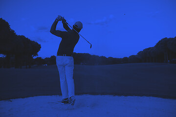 Image showing golfer hitting a sand bunker shot on sunset