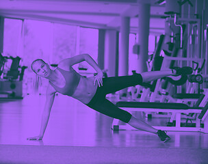 Image showing woman stretching and warming up for her training at a gym