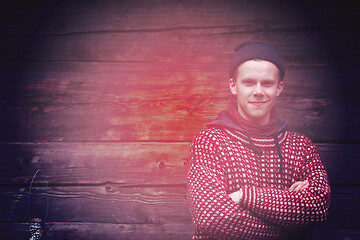 Image showing young hipster in front of wooden house