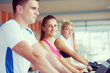 Image showing friends  exercising on a treadmill at the bright modern gym