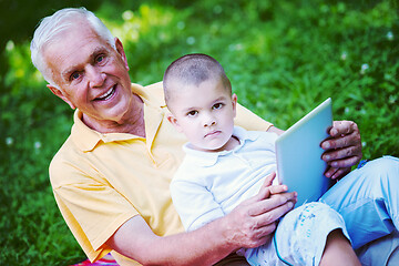 Image showing grandfather and child in park using tablet