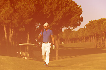 Image showing golfer  walking and carrying golf  bag