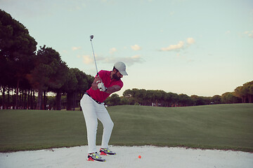 Image showing golfer hitting a sand bunker shot on sunset