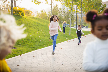 Image showing Interracial group of kids, girls and boys playing together at the park in summer day