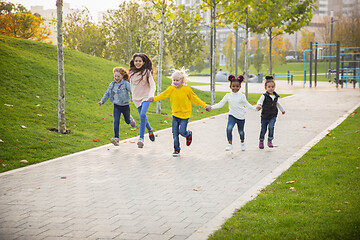 Image showing Interracial group of kids, girls and boys playing together at the park in summer day